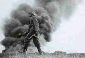 أحد الضباط الألمان من القوات الغازية لأراضي الاتحاد السوفيتي، وفي الخلفية المباني المحترقة نتيجة القصف النازي